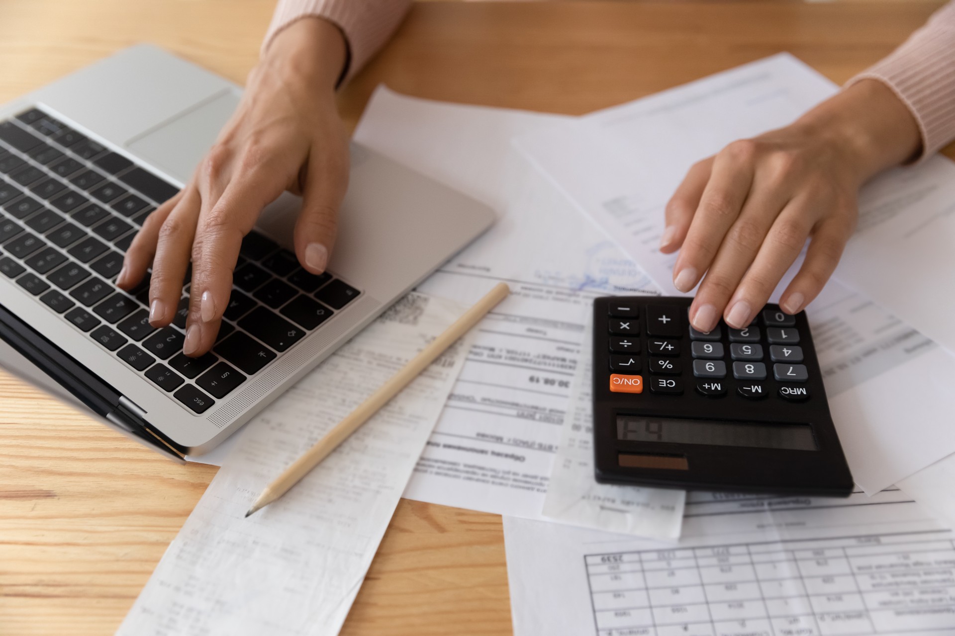 Close up young woman calculating financial expenditures.